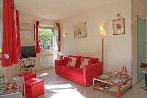 a living room with a red couch and a tv at Casa Limoncello in Taormina