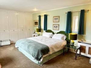 - une chambre avec un grand lit et des rideaux bleus dans l'établissement Whitehouse, à Uplawmoor