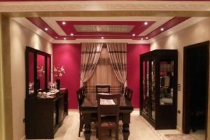 a dining room with a table and a purple wall at City Square Gate 4 - Ultra Apartment - Full Sea View in Alexandria