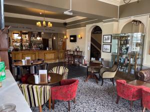 um restaurante com mesas e cadeiras e um bar em Manor Hotel by Greene King Inns em Yeovil