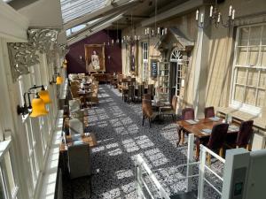 un restaurante con mesas y sillas en un edificio en Manor Hotel by Greene King Inns en Yeovil