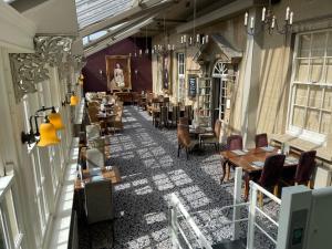 a restaurant with tables and chairs in a building at Manor Hotel by Greene King Inns in Yeovil