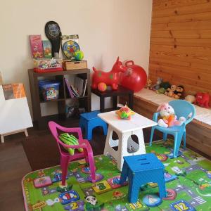 pokój zabaw z krzesłami i stołem oraz domek dla zabawek w obiekcie Green Paradise Kolašin w mieście Kolašin