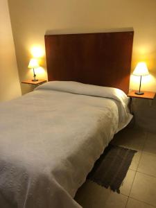 a bedroom with a large white bed with two lamps at Departamento Ensueño in San Fernando del Valle de Catamarca