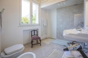 łazienka z toaletą, umywalką i oknem w obiekcie Palazzo Cacace Relais w mieście Meta