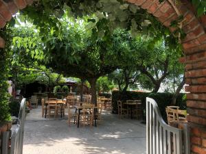 een patio met tafels en stoelen onder een boom bij Villa Muzhaqi in Nivicë