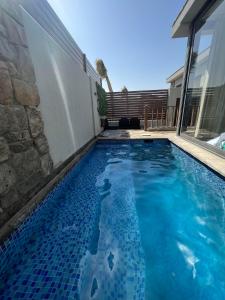 a swimming pool in front of a house at Lovely 1BR with Private Heated pool at El-Gouna in Hurghada