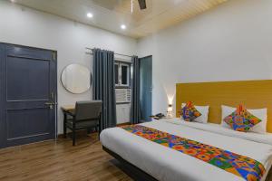 a bedroom with a bed and a desk and a mirror at FabHotel Super 3 Premium II in Kānpur