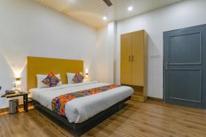 a bedroom with a large bed and a blue door at FabHotel Super 3 Premium II in Kānpur