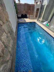 - une piscine avec du carrelage bleu sur le côté d'une maison dans l'établissement Lovely 1BR with Private Heated pool at El-Gouna, à Hurghada
