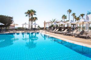 a swimming pool with chairs and umbrellas at a resort at Leonardo Crystal Cove Hotel & Spa – Adults only in Protaras