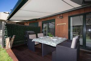 Una mesa y sillas en un patio con parrilla. en Jardín de Saras by BeValle, en Panticosa
