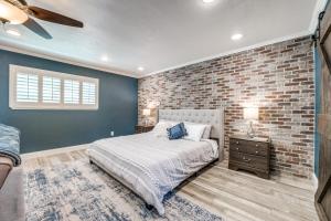 een slaapkamer met een bakstenen muur en een bed bij Charming Pet Friendly 4 BDRM Home Mins To Main ST and Wineries in Fredericksburg