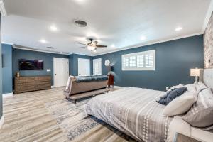 een slaapkamer met blauwe muren en een bed en een bank bij Charming Pet Friendly 4 BDRM Home Mins To Main ST and Wineries in Fredericksburg