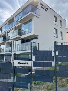 un immeuble d'appartements avec un panneau en face de celui-ci dans l'établissement HIGH STANDARD APARTMENT GDYNIA, à Gdynia