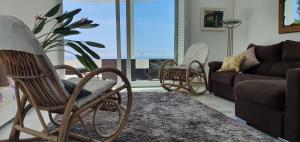リョレート・デ・マルにあるAl lado del mar "Villa Tortuga 12"のリビングルーム(ソファ、椅子付)