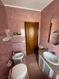 a pink bathroom with a toilet and a sink at Casa del Sole in Ercolano +25 photos