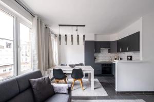 a living room with a table and chairs and a kitchen at Appartement Ann in Blankenberge
