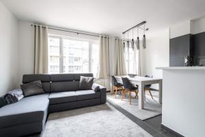 uma sala de estar com um sofá e uma mesa em Appartement Ann em Blankenberge