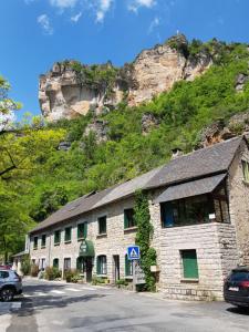 un bâtiment en pierre sur le côté d'une montagne dans l'établissement Hotel de la Jonte, à Meyrueis