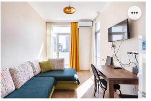 a living room with a couch and a table and a desk at 1BR Cozy apartment in Batumi