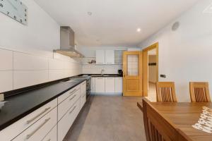 a kitchen with white cabinets and a wooden table at Apartment Bergkristall in Nova Levante