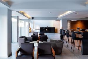 a lobby with chairs and a bar in the background at Oktober Downtown Boutique Hotel in Rhodes Town