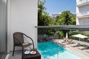 a balcony with a swimming pool and a table and chairs at Oktober Downtown Boutique Hotel in Rhodes Town