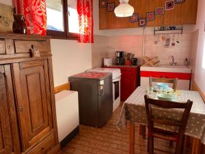una pequeña cocina con mesa y nevera en Studio sympa avec terrasse , maxi 4 pers.Briançon, en Briançon