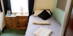 um pequeno quarto com uma cama e uma mesa de cabeceira em Bloomfield Hotel em Blackpool