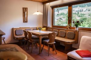 comedor con mesa, sillas y ventana en Apartment Mitterdorfer, en Abfaltersbach