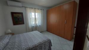 sypialnia z łóżkiem i drewnianą szafką w obiekcie Casa Ariel w mieście Casa Leonardi