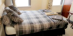 um quarto com uma cama com um cobertor e almofadas em Bloomfield Hotel em Blackpool