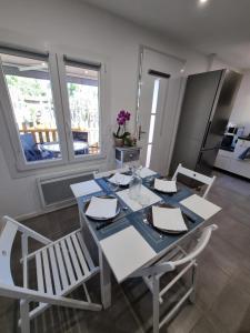 jadalnia z białym stołem i krzesłami w obiekcie La petite Luciole entre mer et montagne. w Cagnes-sur-Mer