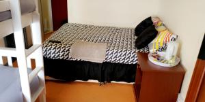 um pequeno quarto com uma cama e uma mesa de cabeceira em Bloomfield Hotel em Blackpool
