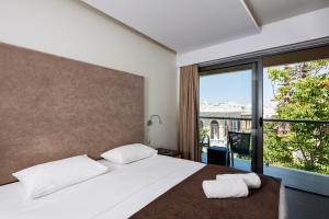 een slaapkamer met een bed en een groot raam bij Oktober Downtown Boutique Hotel in Rhodos-stad