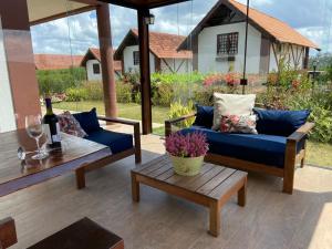 a patio with couches and a table with a bottle of wine at Chalé no Condomínio Serra Nevada I in Bananeiras