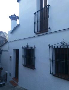 twee poorten aan de zijkant van een wit gebouw bij Casa Alameda in Benarrabá