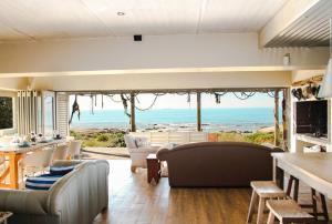 a living room with a view of the ocean at West Coast Beach Villa in St Helena Bay