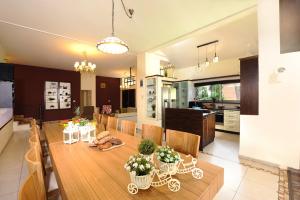 a kitchen and dining room with a wooden table and chairs at SOL Villa Loca in ‘Ein Ya‘aqov
