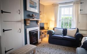 a living room with a chair and a fireplace at Brakestone Cottage in the heart of Port Isaac in Port Isaac