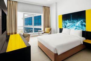 a hotel room with a bed and a desk and a room at Adagio Premium Dubai Al Barsha in Dubai