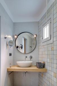 a bathroom with a sink and a mirror at Calma Boutique Hotel in Posidhonía