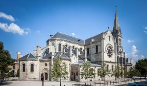 un gran edificio con una iglesia con una torre de reloj en Appartement une chambre proche PARIS, en Argenteuil