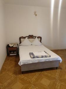 Schlafzimmer mit einem Bett mit weißer Bettwäsche und Kissen in der Unterkunft Hayots Ojakh in Sewan