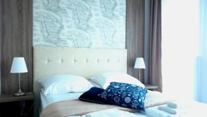 łóżko z dwoma poduszkami i mapą na ścianie w obiekcie Willa Długa No. 4 Bed & Breakfast w mieście Gdynia