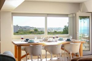 a dining room with a table and chairs and a large window at West Coast Beach Villa in St Helena Bay