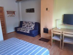a living room with a blue couch and a desk at Jõesuu Home Accommodation in Purtsi