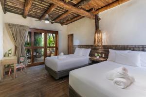 una camera da letto con due letti e una finestra di Hidden Treehouse Tulum Eco-Hotel a Tulum Altre 37 foto