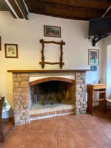 a living room with a stone fireplace at Casa marciana alta in Marciana